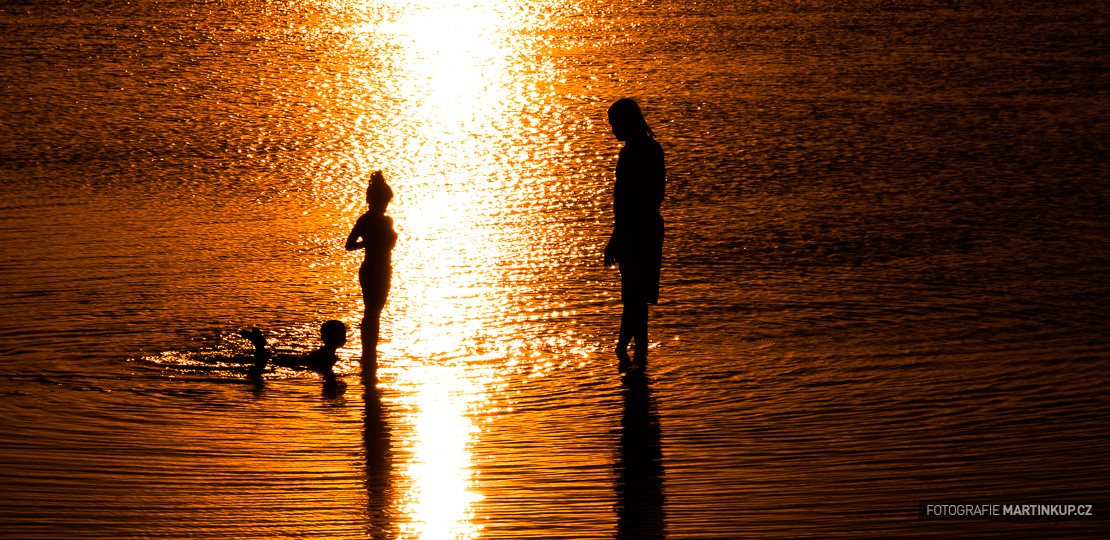 Koupání rodiny při západu slunce (Mauritius)